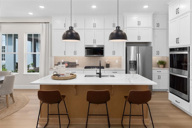 2486 Celebration Blvd, Celebration, FL 34747 - kitchen featuring appliances with stainless steel finishes, light wood finished floors, backsplash, recessed lighting, and white cabinetry