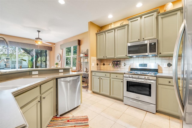 5263 Beach River Rd, Windermere, FL 34786 - kitchen with stainless steel appliances, backsplash, cream cabinets, ceiling fan, and recessed lighting
