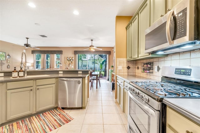 5263 Beach River Rd, Windermere, FL 34786 - kitchen with appliances with stainless steel finishes, ceiling fan, light tile patterned floors, decorative backsplash, and recessed lighting