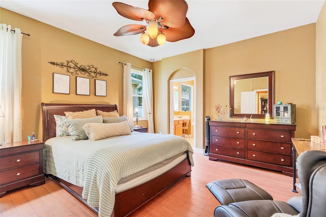 5263 Beach River Rd, Windermere, FL 34786 - bedroom with connected bathroom, light wood-style flooring, and a ceiling fan