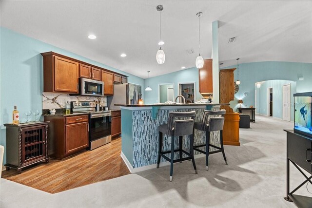 1787 Attilburgh Blvd, Melbourne, FL 32904 - kitchen featuring stainless steel appliances, dark countertops, a kitchen bar, hanging light fixtures, and vaulted ceiling