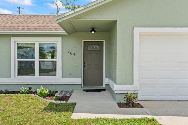 705 Ibis Ave, Deltona, FL 32738 - property entrance featuring stucco siding, roof with shingles, and an attached garage