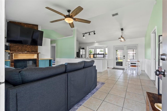 705 Ibis Ave, Deltona, FL 32738 - living room featuring french doors, vaulted ceiling, light tile patterned floors, a large fireplace, and ceiling fan