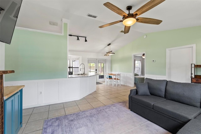 705 Ibis Ave, Deltona, FL 32738 - living area with a ceiling fan, wainscoting, light tile patterned flooring, french doors, and vaulted ceiling