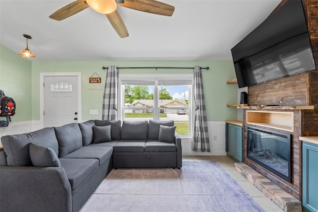 705 Ibis Ave, Deltona, FL 32738 - living room with a wainscoted wall, a large fireplace, light tile patterned floors, and ceiling fan