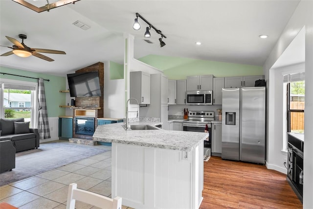 705 Ibis Ave, Deltona, FL 32738 - kitchen with stainless steel appliances, lofted ceiling, open floor plan, a peninsula, and gray cabinetry