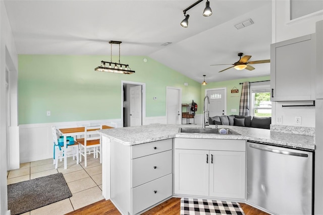 705 Ibis Ave, Deltona, FL 32738 - kitchen with stainless steel dishwasher, a wainscoted wall, a peninsula, vaulted ceiling, and ceiling fan