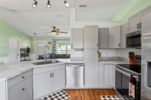 705 Ibis Ave, Deltona, FL 32738 - kitchen featuring stainless steel appliances, a peninsula, lofted ceiling, ceiling fan, and light wood-style flooring