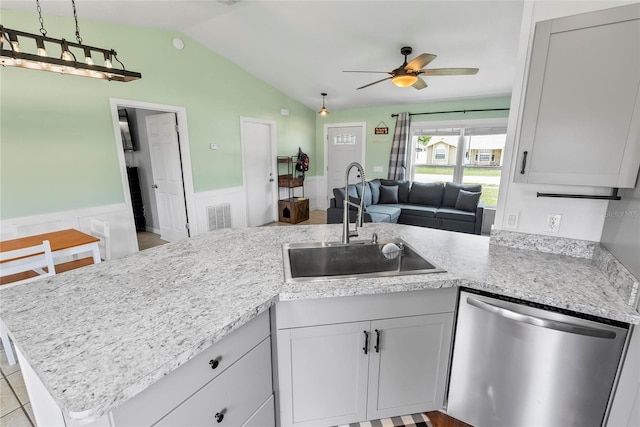 705 Ibis Ave, Deltona, FL 32738 - kitchen with stainless steel dishwasher, a wainscoted wall, lofted ceiling, a ceiling fan, and open floor plan