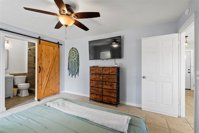 705 Ibis Ave, Deltona, FL 32738 - bedroom with a barn door, light tile patterned floors, ceiling fan, and connected bathroom