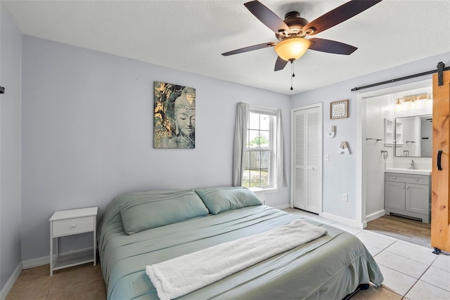 705 Ibis Ave, Deltona, FL 32738 - bedroom with a closet, light tile patterned floors, a barn door, and ensuite bathroom