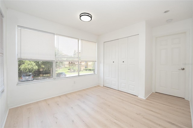 5160 Conroy Rd Unit 21, Orlando, FL 32811 - unfurnished bedroom featuring multiple windows, light wood-type flooring, and a closet