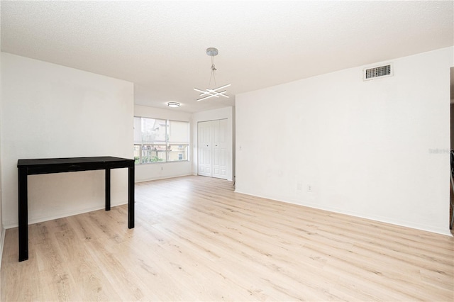 5160 Conroy Rd Unit 21, Orlando, FL 32811 - empty room with light wood finished floors and a chandelier