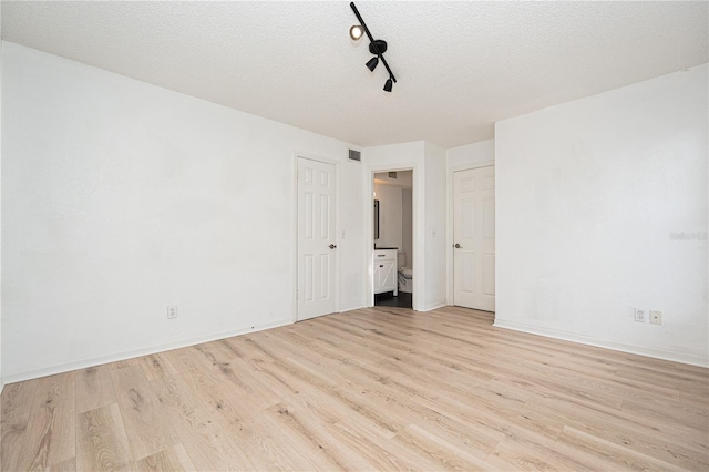 5160 Conroy Rd Unit 21, Orlando, FL 32811 - spare room featuring light wood-style flooring, track lighting, and a textured ceiling