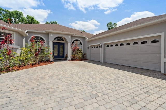 1542 Wescott Loop, Winter Springs, FL 32708 - view of front of house featuring french doors, decorative driveway, stucco siding, and an attached garage