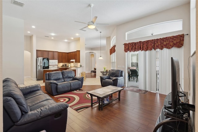 1542 Wescott Loop, Winter Springs, FL 32708 - living area featuring arched walkways, a ceiling fan, a towering ceiling, recessed lighting, and light wood-style floors