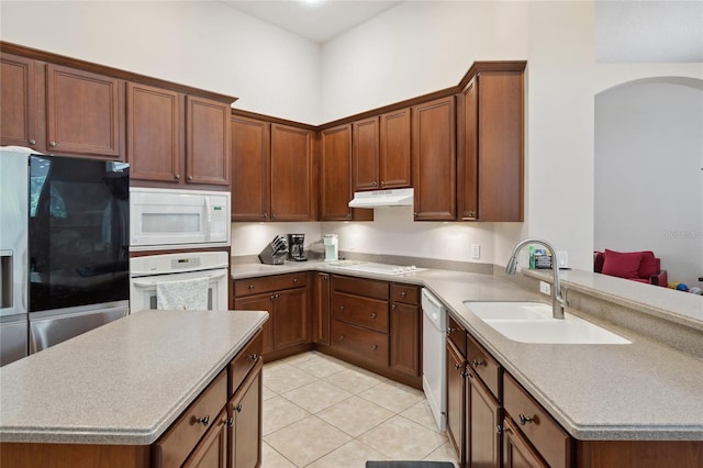 1542 Wescott Loop, Winter Springs, FL 32708 - kitchen featuring white appliances, arched walkways, light tile patterned flooring, under cabinet range hood, and light countertops