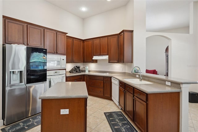 1542 Wescott Loop, Winter Springs, FL 32708 - kitchen with white appliances, under cabinet range hood, arched walkways, a peninsula, and light tile patterned floors