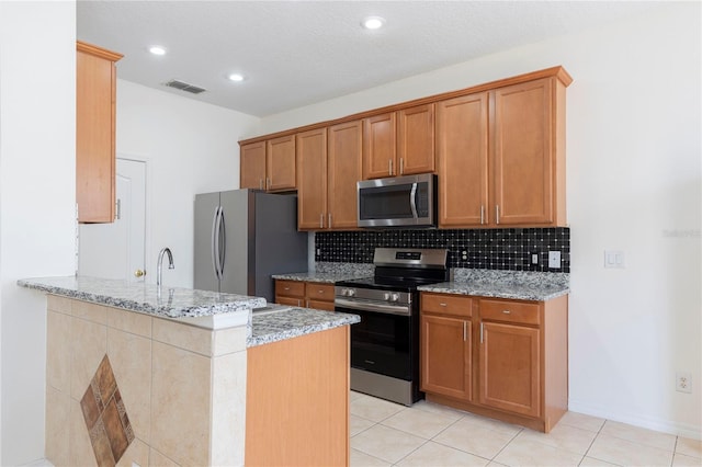 2211 J Lawson Blvd, Orlando, FL 32824 - kitchen with stainless steel appliances, backsplash, light stone countertops, light tile patterned flooring, and recessed lighting
