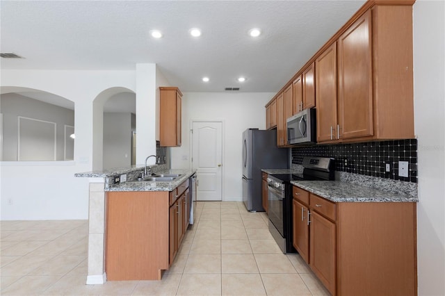 2211 J Lawson Blvd, Orlando, FL 32824 - kitchen featuring stainless steel appliances, brown cabinetry, backsplash, and recessed lighting