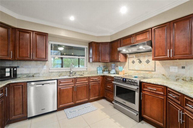 209 7th St S, Haines City, FL 33844 - kitchen with stainless steel appliances, under cabinet range hood, light stone countertops, backsplash, and crown molding