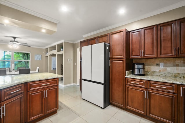 209 7th St S, Haines City, FL 33844 - kitchen with freestanding refrigerator, ceiling fan, ornamental molding, backsplash, and light stone countertops