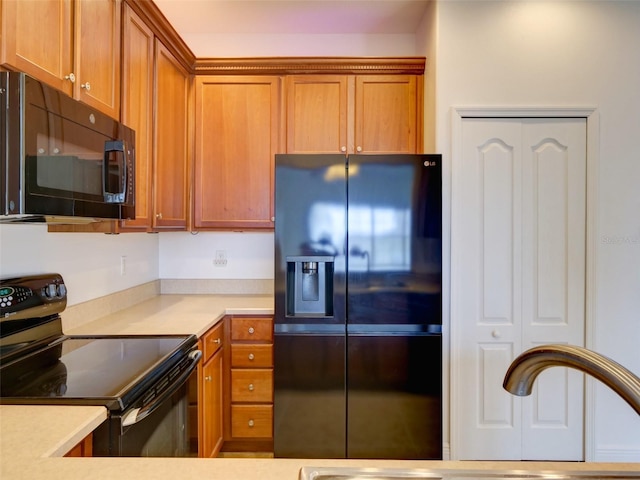 17322 Chateau Pine Way, Clermont, FL 34711 - kitchen with black appliances, brown cabinetry, and light countertops