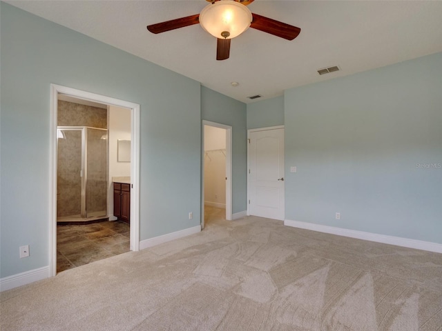 17322 Chateau Pine Way, Clermont, FL 34711 - unfurnished bedroom featuring light colored carpet, a spacious closet, a closet, ensuite bathroom, and a ceiling fan