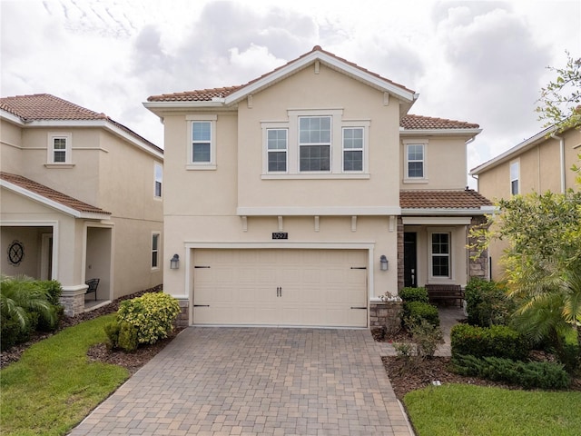 1097 Trappers Trail Loop, Davenport, FL 33896 - view of front facade featuring a tile roof, decorative driveway, stone siding, and a garage