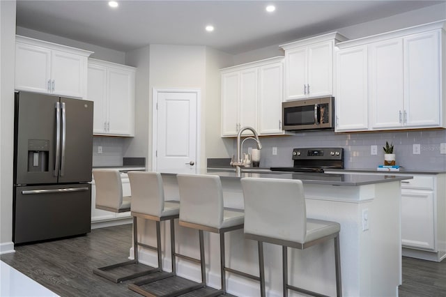1097 Trappers Trail Loop, Davenport, FL 33896 - kitchen with stainless steel appliances, dark wood-type flooring, tasteful backsplash, a center island with sink, and recessed lighting