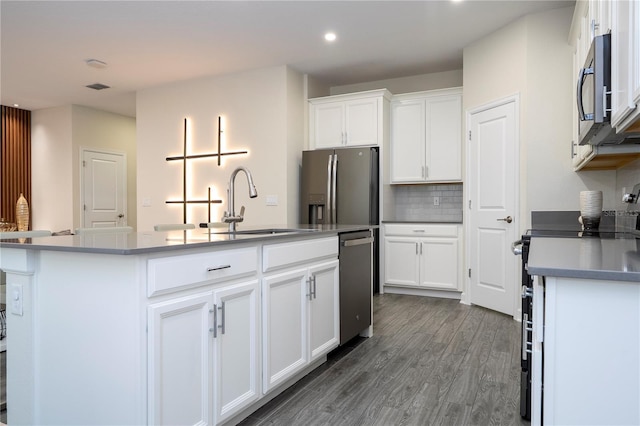 1097 Trappers Trail Loop, Davenport, FL 33896 - kitchen with stainless steel appliances, recessed lighting, white cabinets, a center island with sink, and backsplash