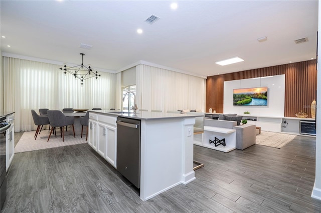 1097 Trappers Trail Loop, Davenport, FL 33896 - kitchen with stainless steel dishwasher, a chandelier, wood finished floors, an island with sink, and white cabinetry