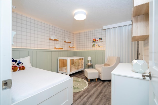 1097 Trappers Trail Loop, Davenport, FL 33896 - bedroom with wainscoting, wood finished floors, wallpapered walls, and a nursery area