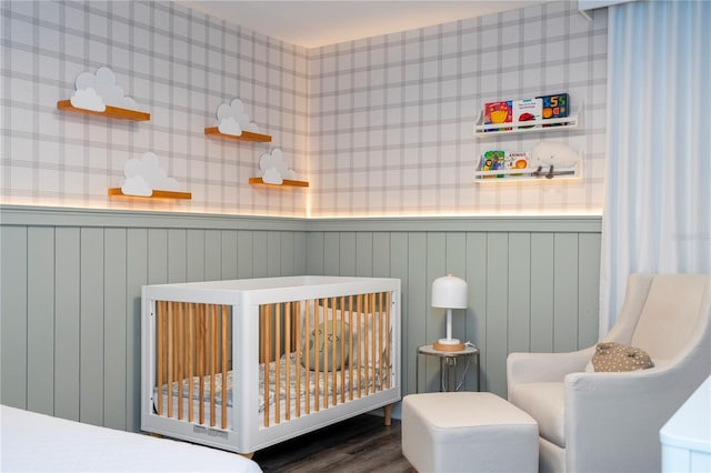 1097 Trappers Trail Loop, Davenport, FL 33896 - bedroom with a crib, a wainscoted wall, wood finished floors, and wallpapered walls