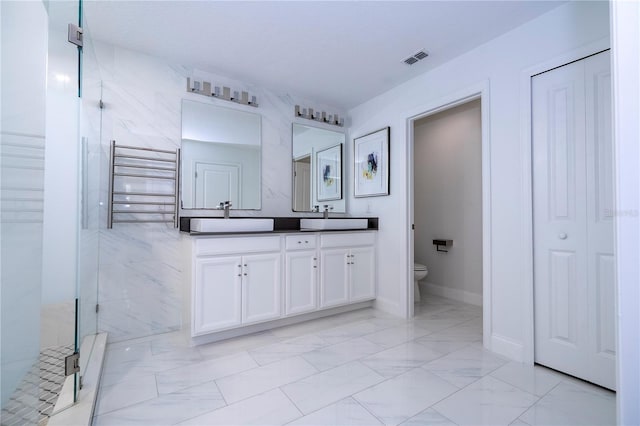 1097 Trappers Trail Loop, Davenport, FL 33896 - bathroom with radiator, double vanity, marble finish flooring, a stall shower, and a closet