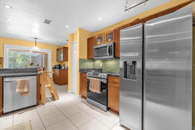 9275 Lake Sharp Ct, Orlando, FL 32817 - kitchen featuring appliances with stainless steel finishes, glass insert cabinets, brown cabinets, backsplash, and recessed lighting
