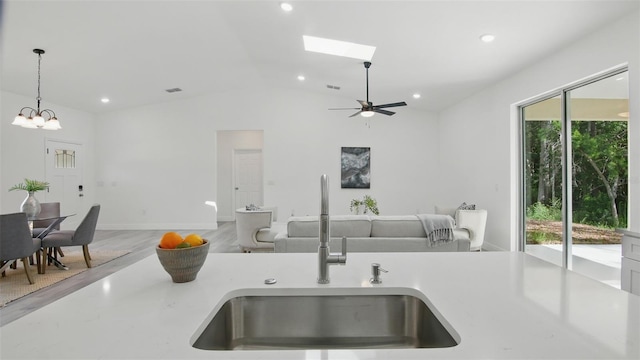 17 Cypress Run, Haines City, FL 33844 - kitchen with pendant lighting, open floor plan, light countertops, vaulted ceiling, and a skylight