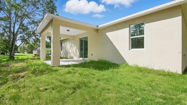 17 Cypress Run, Haines City, FL 33844 - back of property featuring stucco siding, a patio area, and a yard