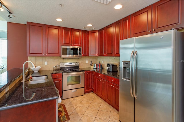 101 S Eola Dr Unit 1021, Orlando, FL 32801 - kitchen featuring appliances with stainless steel finishes, dark brown cabinets, backsplash, a textured ceiling, and a peninsula