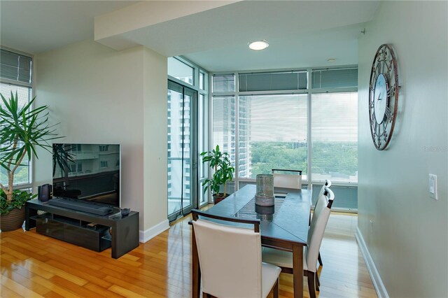 101 S Eola Dr Unit 1021, Orlando, FL 32801 - dining area with a wall of windows and light wood-type flooring