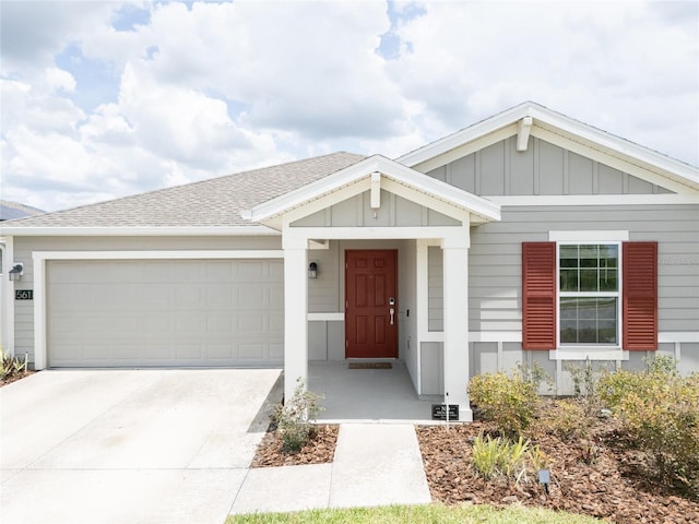 561 Andrea Cir S, Haines City, FL 33844 - view of front of house featuring board and batten siding, a garage, concrete driveway, and a shingled roof