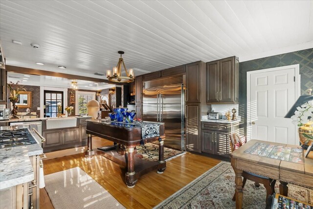 8407 Interbay Blvd, Tampa, FL 33616 - kitchen with built in refrigerator, wallpapered walls, light wood-type flooring, a chandelier, and a peninsula