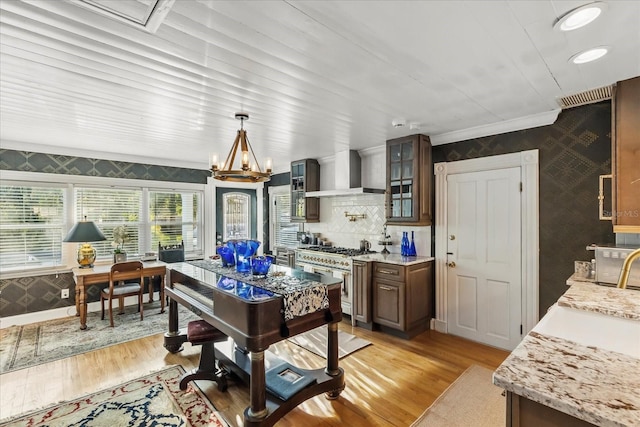 8407 Interbay Blvd, Tampa, FL 33616 - dining area featuring wallpapered walls, light wood-type flooring, an accent wall, crown molding, and a chandelier