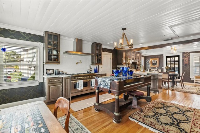 8407 Interbay Blvd, Tampa, FL 33616 - kitchen featuring wall chimney exhaust hood, double oven range, light wood-style floors, ornamental molding, and light countertops