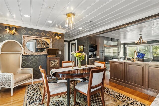 8407 Interbay Blvd, Tampa, FL 33616 - dining space with wallpapered walls, light wood finished floors, a chandelier, an accent wall, and recessed lighting