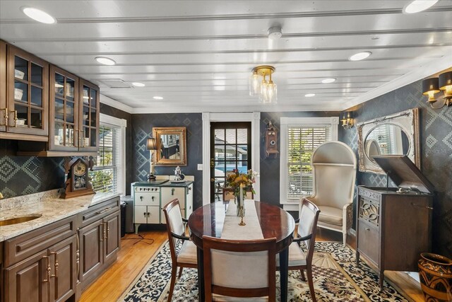 8407 Interbay Blvd, Tampa, FL 33616 - dining space featuring wallpapered walls, ornamental molding, light wood finished floors, plenty of natural light, and a chandelier