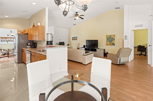 6453 Alcalde Ct Unit 110, Orlando, FL 32835 - kitchen with a chandelier, high vaulted ceiling, appliances with stainless steel finishes, open floor plan, and light wood-style flooring