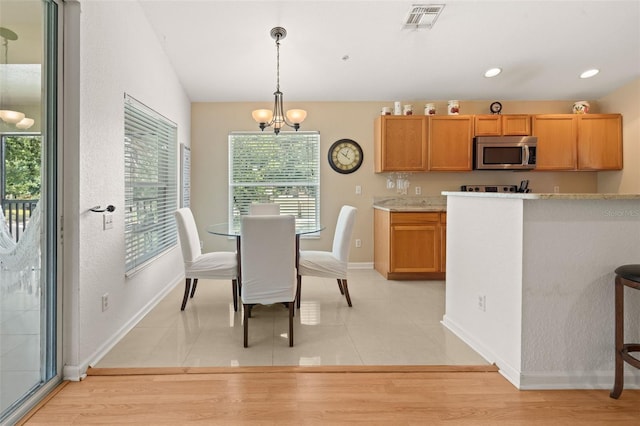 6453 Alcalde Ct Unit 110, Orlando, FL 32835 - kitchen featuring stainless steel microwave, light countertops, a chandelier, decorative light fixtures, and recessed lighting