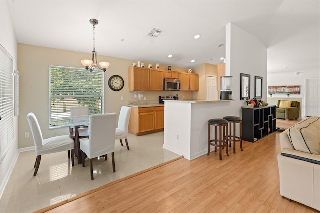 6453 Alcalde Ct Unit 110, Orlando, FL 32835 - dining area featuring light wood-type flooring, a chandelier, and recessed lighting