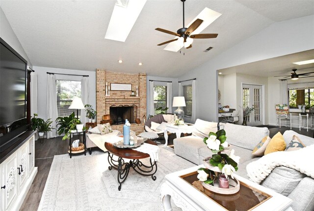 26 Canter Club Ct, Debary, FL 32713 - living room with vaulted ceiling, a ceiling fan, dark wood-style floors, a skylight, and a fireplace